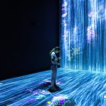 A woman standing in front of an Artificial Intelligence simulator